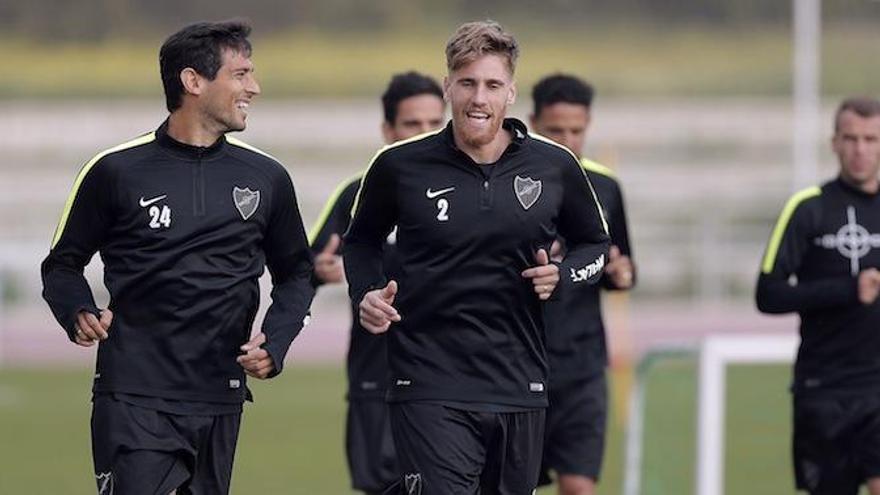 Roque Santa Cruz y Raúl Albentosa bromean durante el entrenamiento de ayer en el Ciudad de Málaga, que supuso la vuelta al trabajo del Málaga CF.