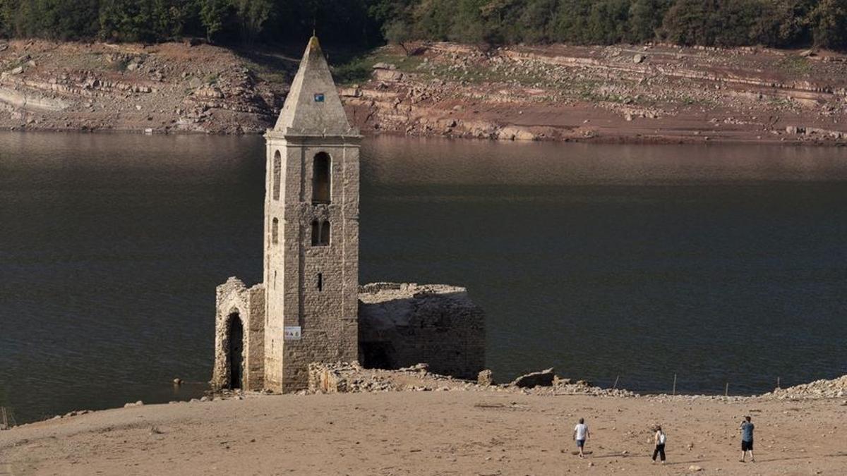 Unos turistas se acercan a la iglesia de Sau.