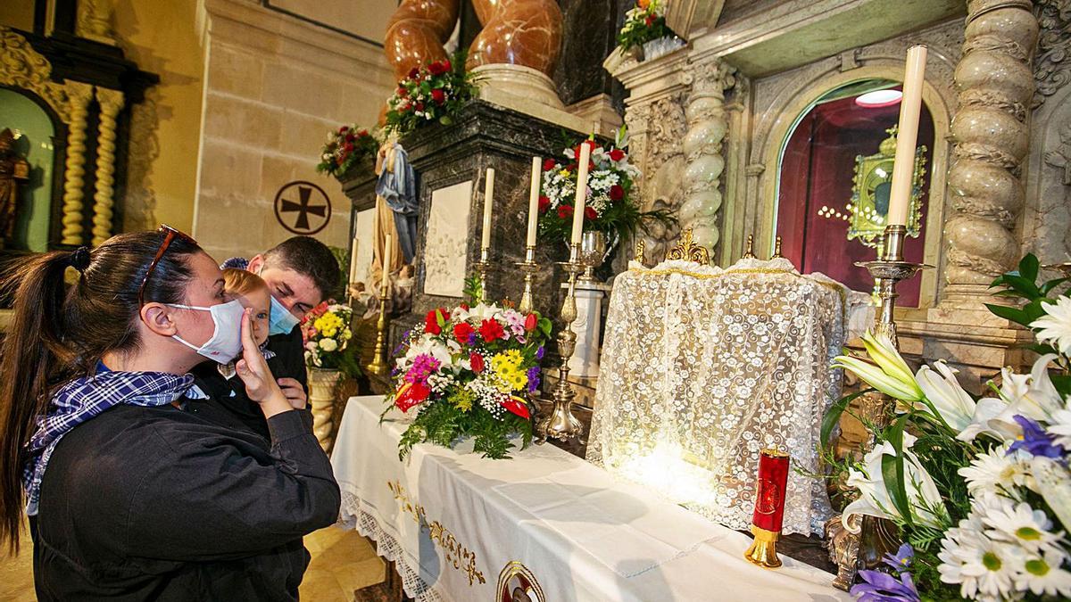 Una pareja presenta a su bebé a la Reliquia de la Santa Faz.