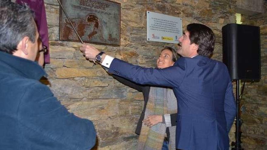 Suárez-Quiñones y Odile Rodríguez descubren la placa, ante la imagen de Félix Rodríguez encariñado con un lobo y, a la derecha, Odile observa los ejemplares del Centro del Lobo.