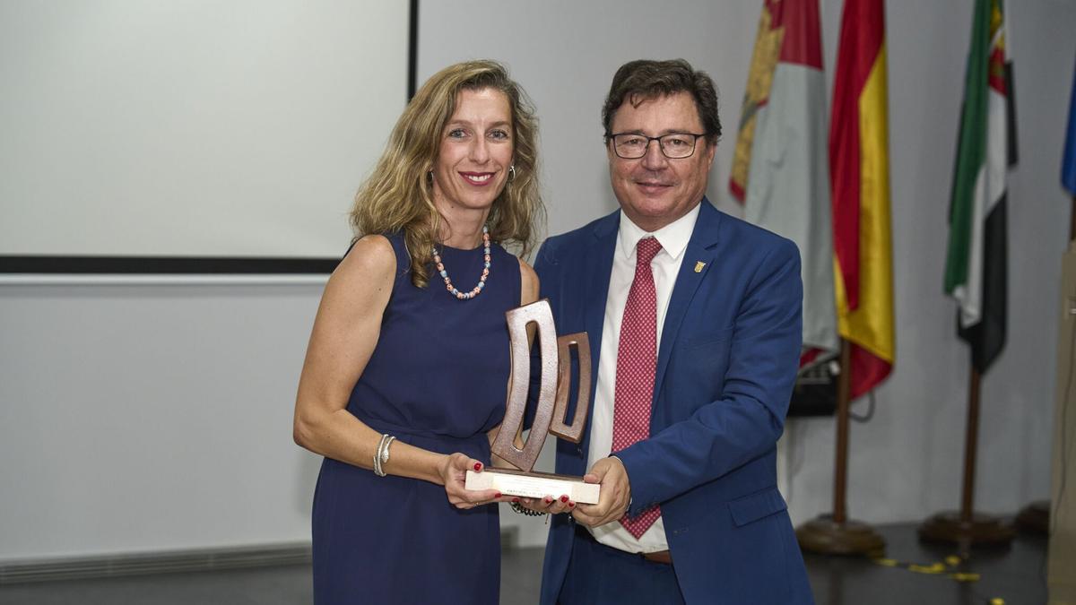 Rebeca Bao, directora de RRHH, de GEFISCAL, recibe el galardón que le entrega el consejero de Economía, Guillermo Santamaría.
