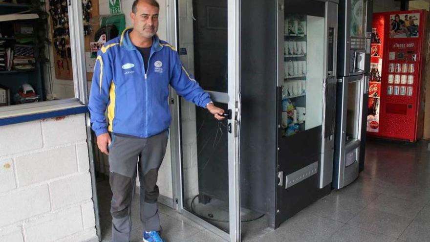 Juan Carlos Fernández muestra una de las puertas forzadas junto a las máquinas que fueron objeto del robo en la madrugada de ayer en el polideportivo de Noreña.