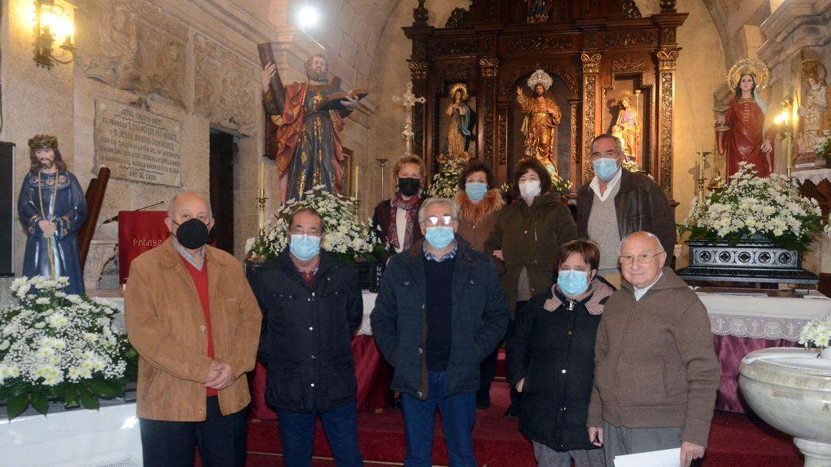 Miembros de la directiva de la asociación de vecinos, ayer en la iglesia parroquial, junto a las imágenes de los tres santos