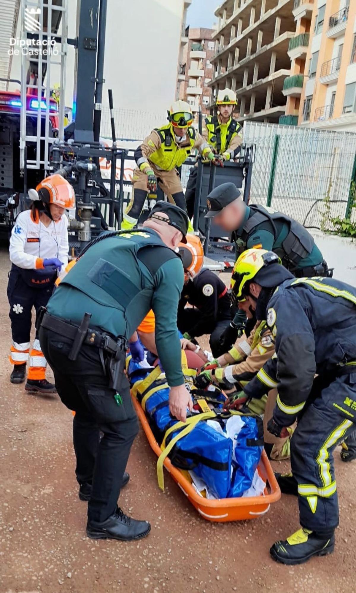 Los bomberos traslada en camilla al herido.