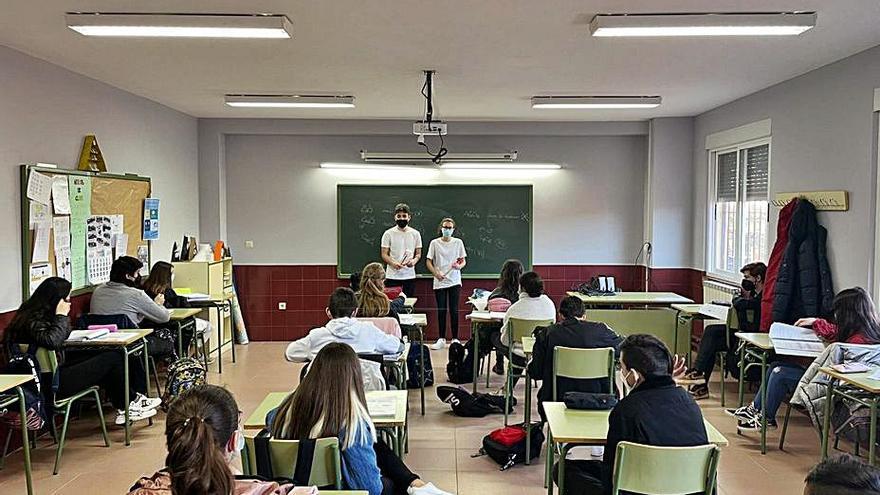 Entrega de dos claveles en un aula.