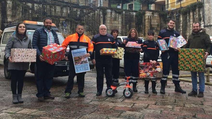 Autoridades y voluntarios de Protección Civil de Piloña, ayer, durante la presentación de la campaña de recogida de juguetes en Infiesto.