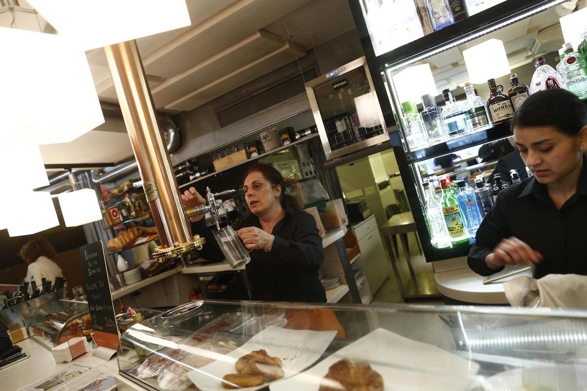 Dos trabajadoras de la hostelería detrás de la barra de un bar.