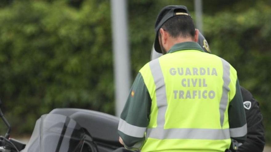 Un agente de la Guardia Civil de Tráfico en un control con un motorista.