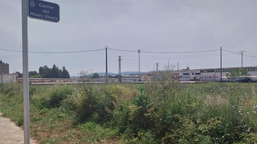 Uno de los descampados, con naves al fondo, incluidos en el plan urbanístico de l’Anella de Gandia.