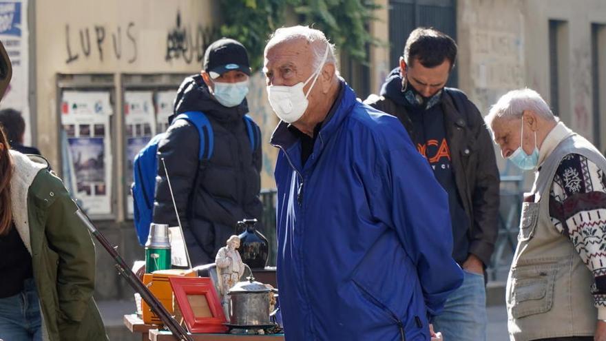 Ciudadanos con mascarilla en un mercado de Turín.