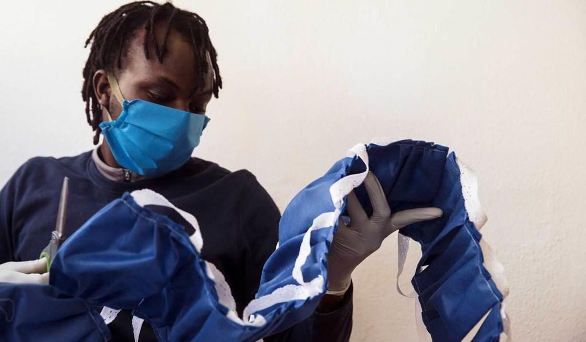 Una persona en riesgo de exclusión participa en la fabricación de mascarillas en Málaga.