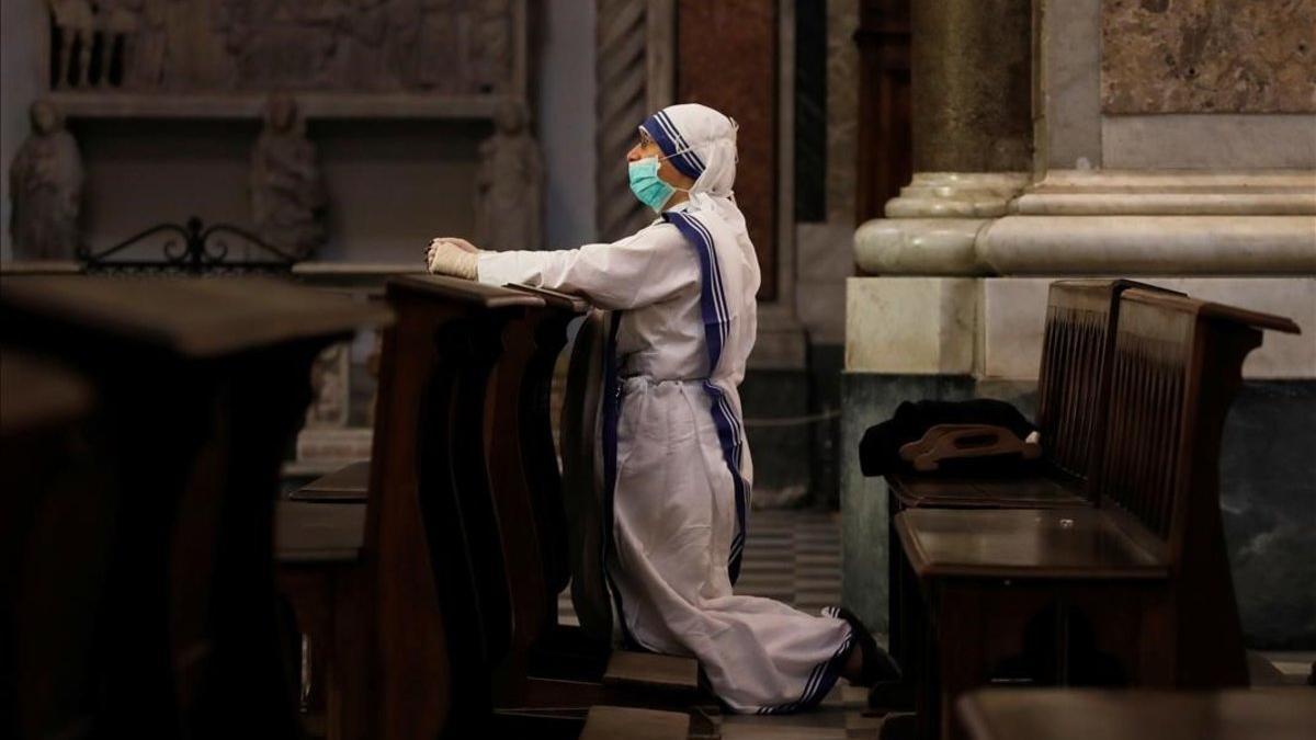 Una monja se protege con mascarilla durante una misa en la catedral de Nápoles.