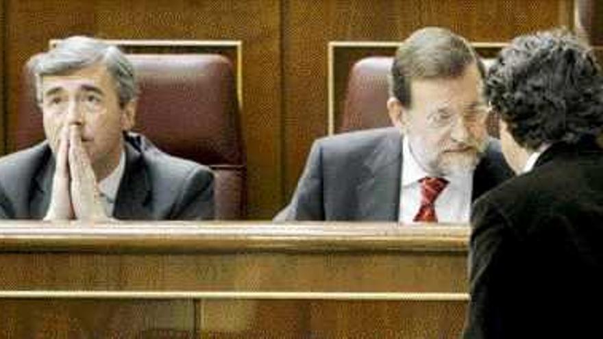 Mariano Rajoy conversa con Jorge Moragas en presencia de Ángel Acebes, ayer en el Congreso. / Manuel H. de León