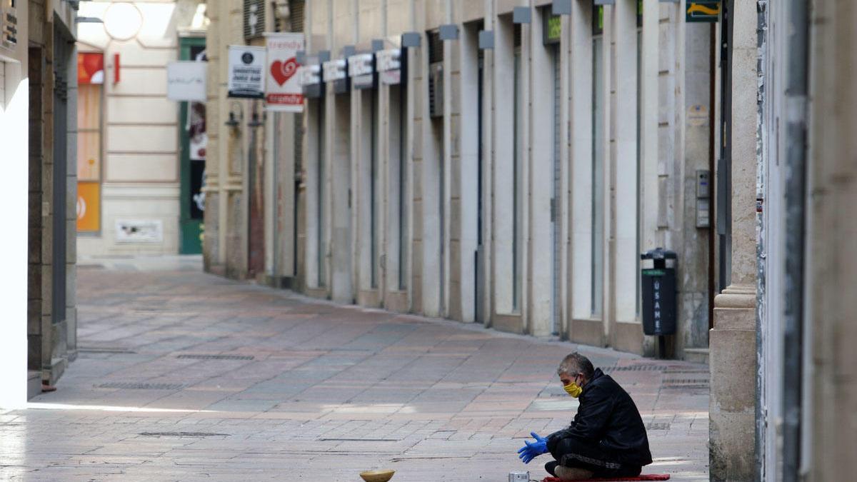 Una persona sin hogar pide en el centro de Málaga.