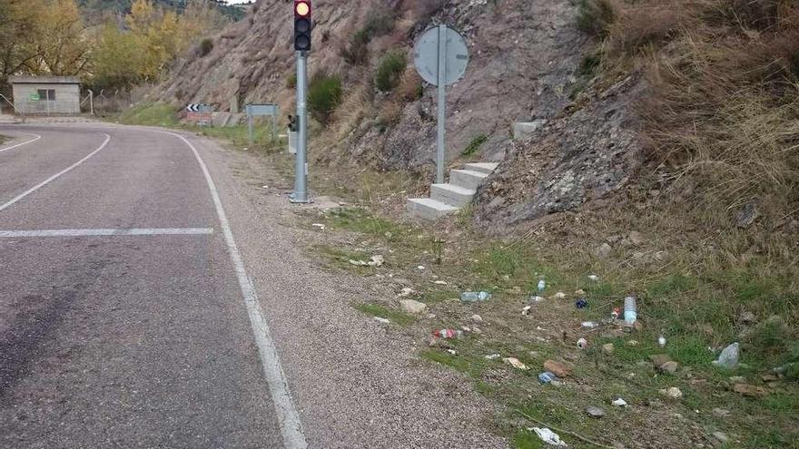 Botellas y residuos tirados por los usuarios en la cuneta, a la entrada de la presa de Villalcampo.