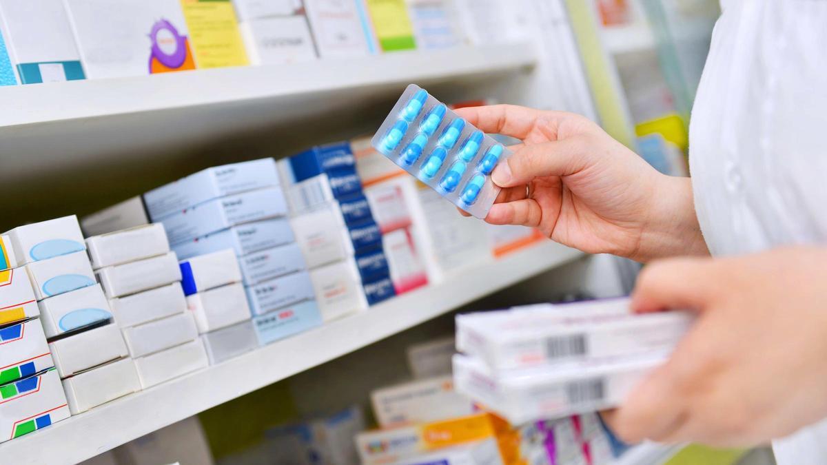 Imagen de archivo de una farmacéutica ordenando medicamentos.