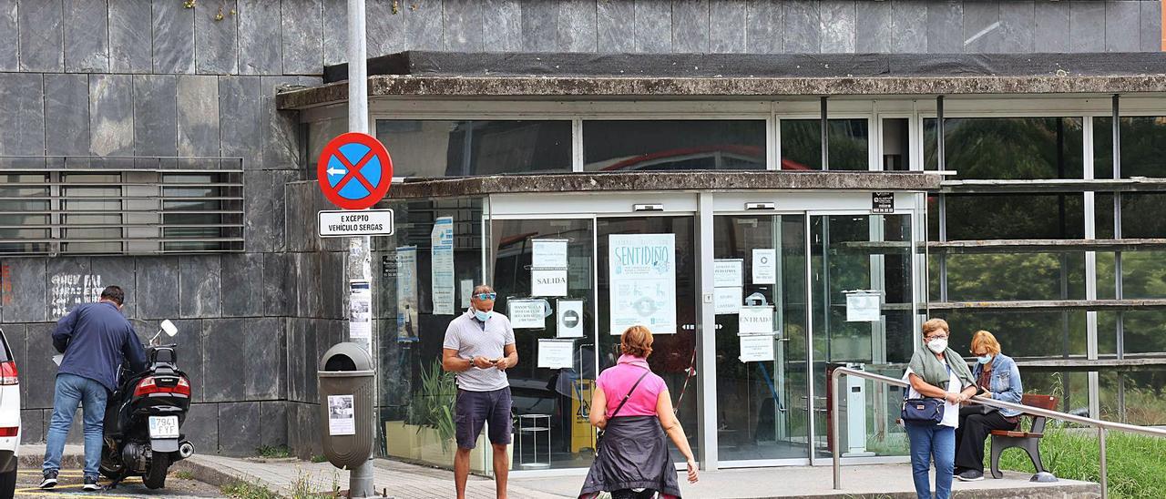 Usuarios en el exterior del centro de salud de Teis.