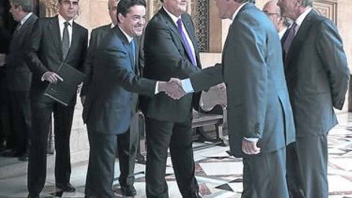 Enrique Bañuelos, a la izquierda, da la mano al president en el Palau de la Generalitat, en septiembre del 2012.