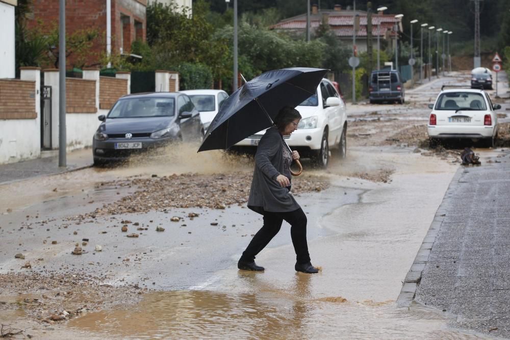 Una dona travessant un carrer inundat i brut a Medinyà