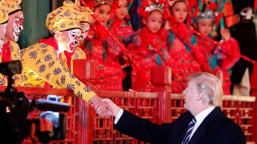 Trump saluda a un grupo de actores en la Ciudad Prohibida de Pekín.