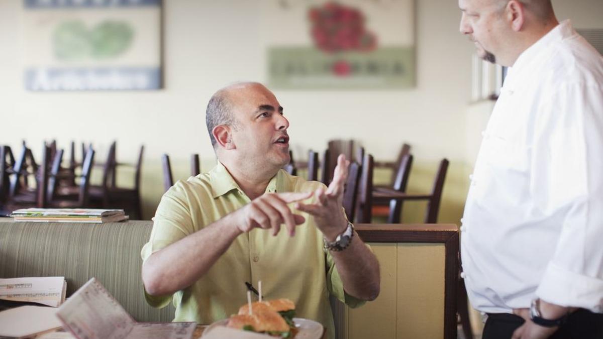 Un cliente discute con un camarero en un restaurante.