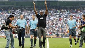Usain Bolt saluda al público tras realizar el saque de honor en un partido en el Bernabéu