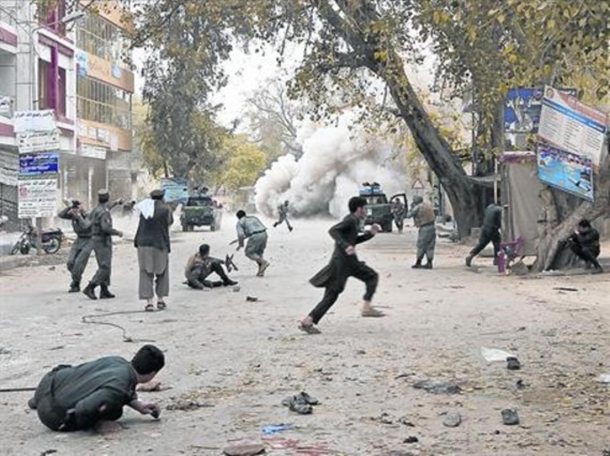 Civils i militars afganesos corren després de l’atemptat suïcida comès a Jalalabad, ahir.