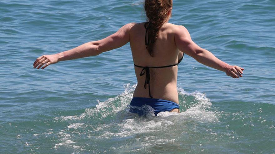 Una joven entra en el agua en La Malagueta, el último fin de semana de marzo.