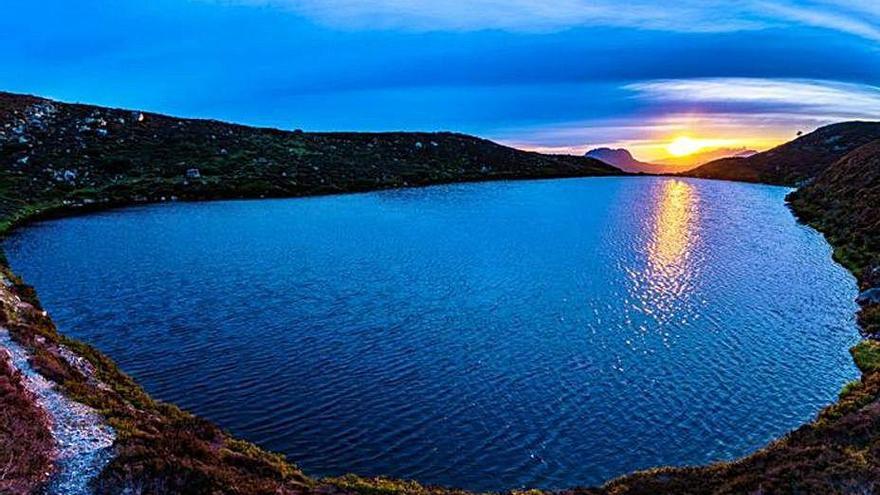 Fotografía ganadora: el lago Ubales, en el parque natural de Redes. A la derecha, el ganador recogiendo su premio.