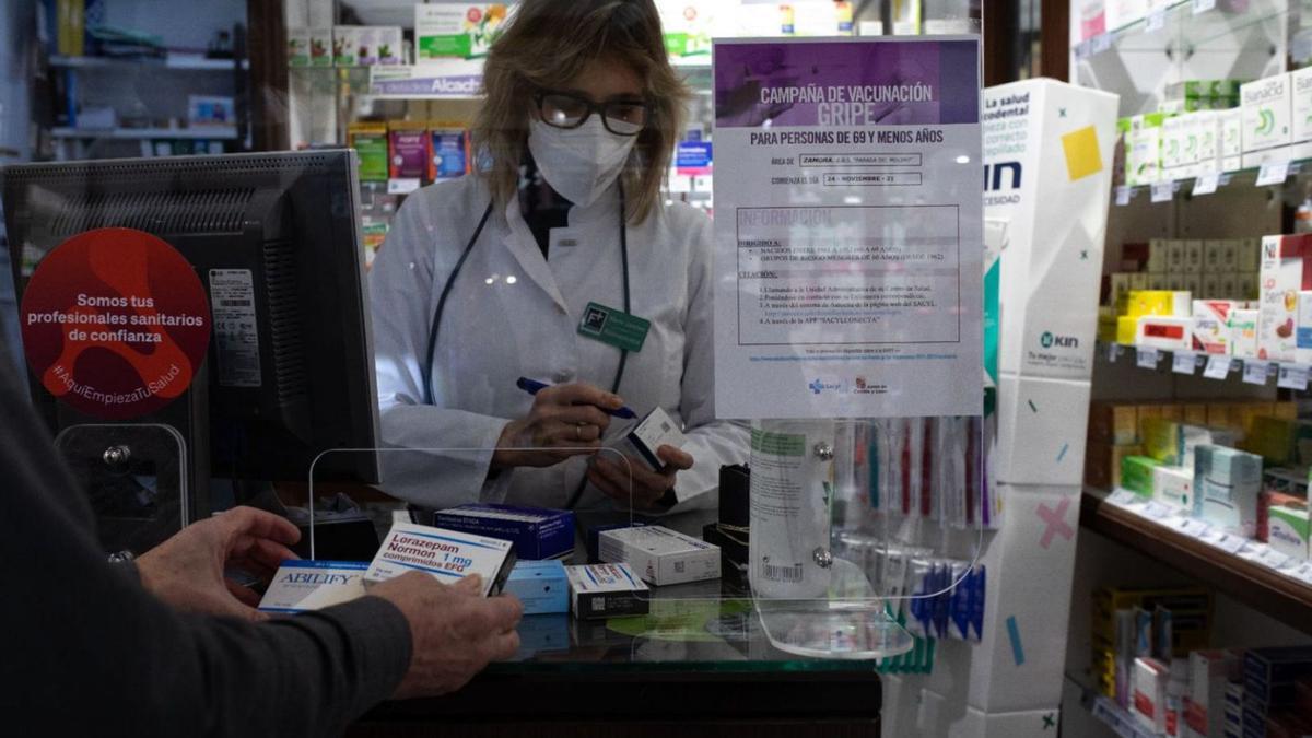 Una trabajadora de una farmacia despacha varios medicamentos. | Ana Burrieza