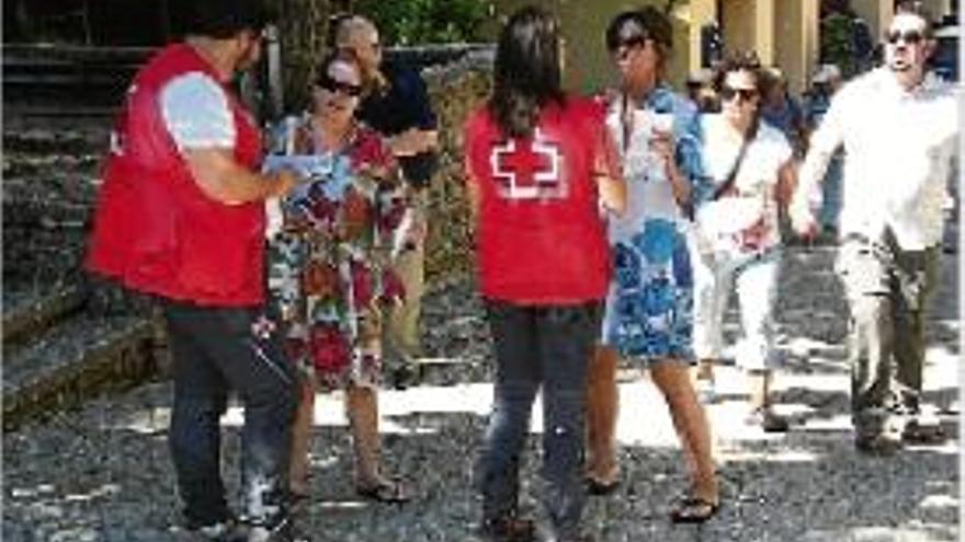 Creu Roja repartint els díptics entre els visitants, ahir al matí