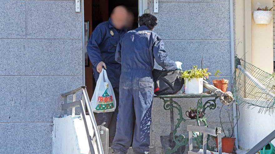 Agente de la Policía con bolsas extraídas de la casa de la víctima. // Marta G. Brea