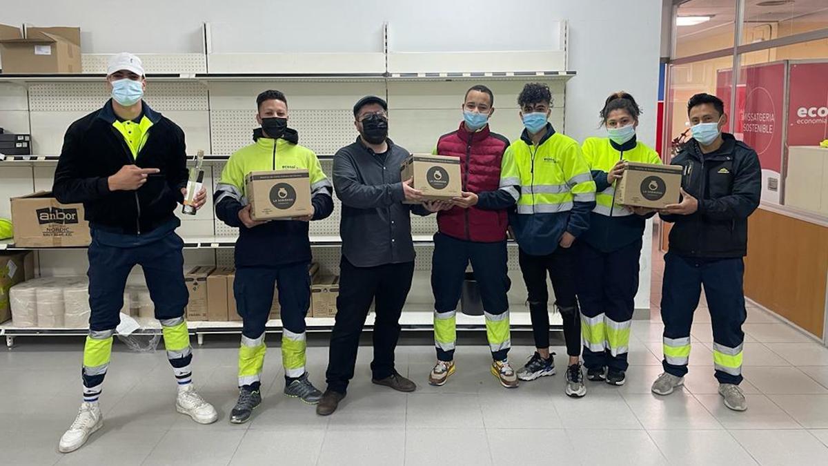 Diversos treballadors d&#039;Ecosol amb els responsables de la cooperativa la Sobirana repartint alguns dels productes que produeix aquesta empresa de licors