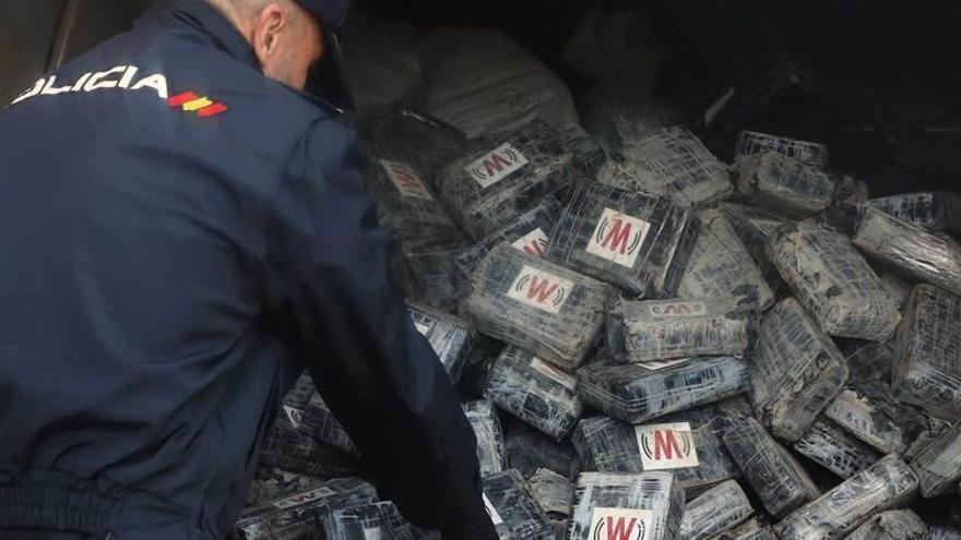 Un agente de la Policía Nacional con la cocaína desenterrada.