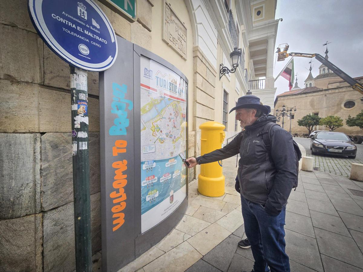 Un turista italiano observa el panel informativo del turismo en la plaza de España de Badajoz.