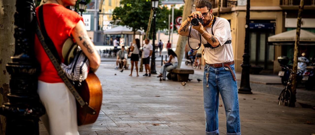 Fabio fotografía a un músico en el paseo del Born.