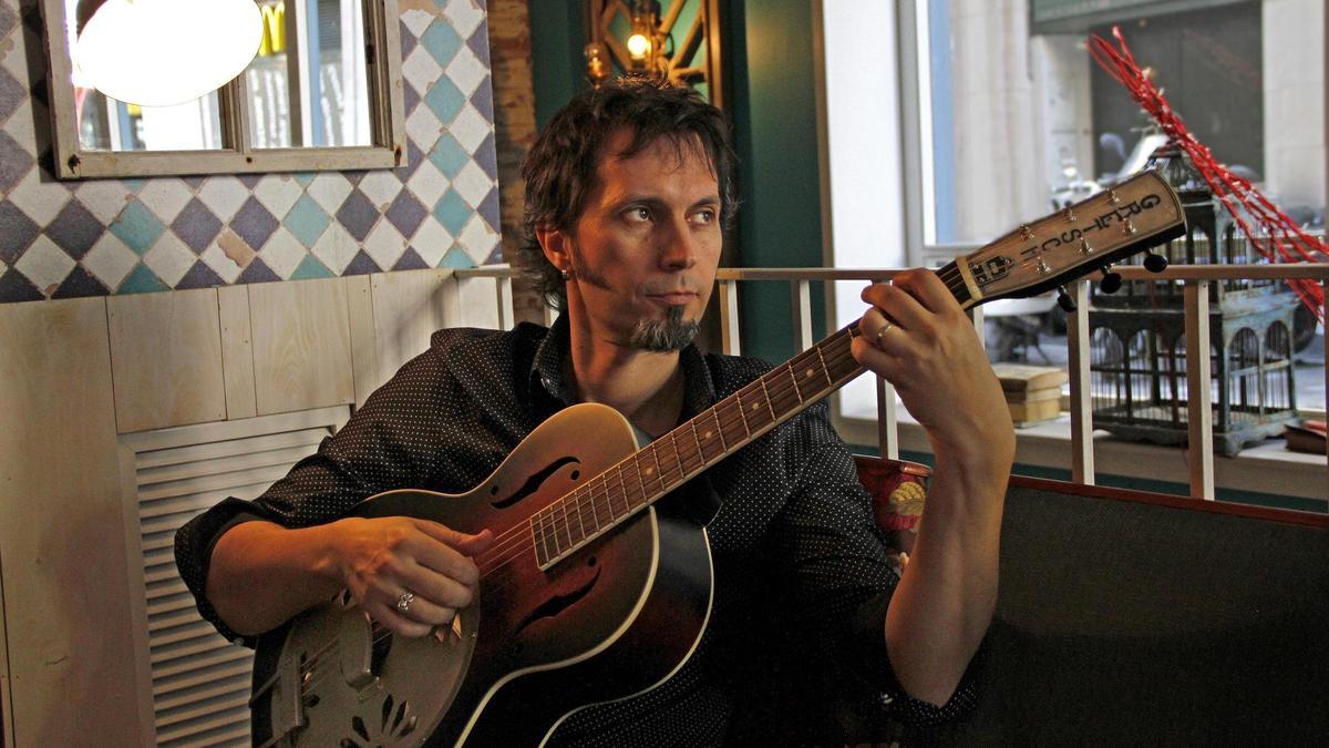 David Angulo (Zaragoza, 1972) posa con su guitarra en un bar de la ciudad.