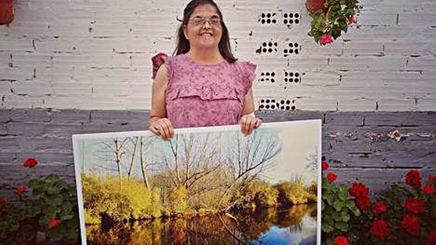 Rosabel Pérez posando con la ampliación de su fotografía.