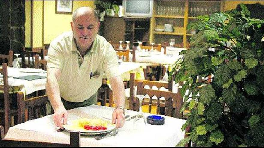 Antonio Joaquín Alves, ofreciendo una de las propuestas de bacalao en el comedor de su establecimiento.