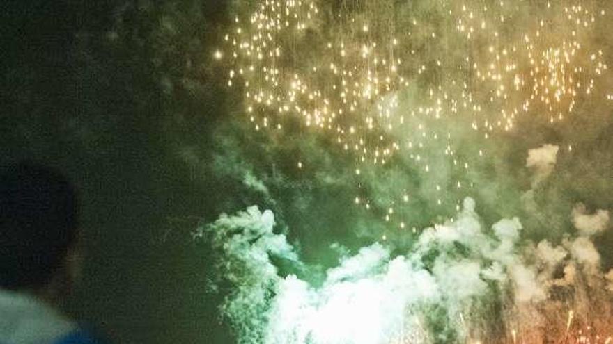 Un joven observa los fuegos artificiales.