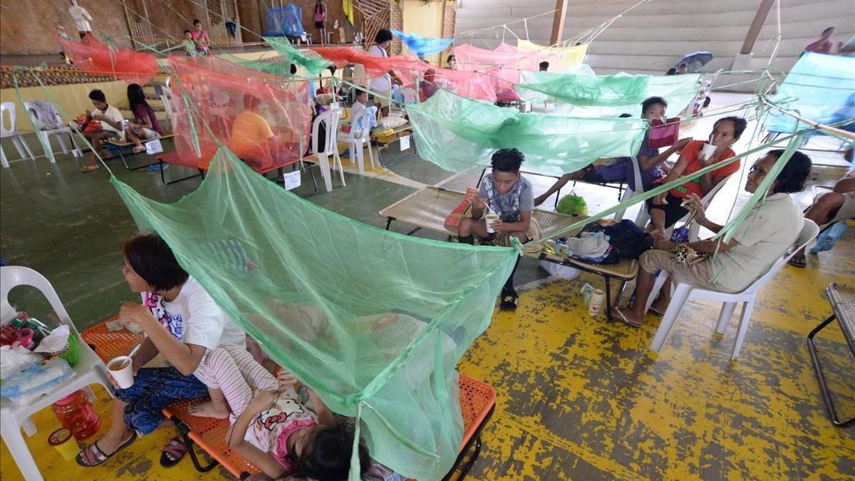 Pacientes que sufren de dengue descansan en un gimnasio cubiertos con mosquiteros en la ciudad de Maasin, Filipinas