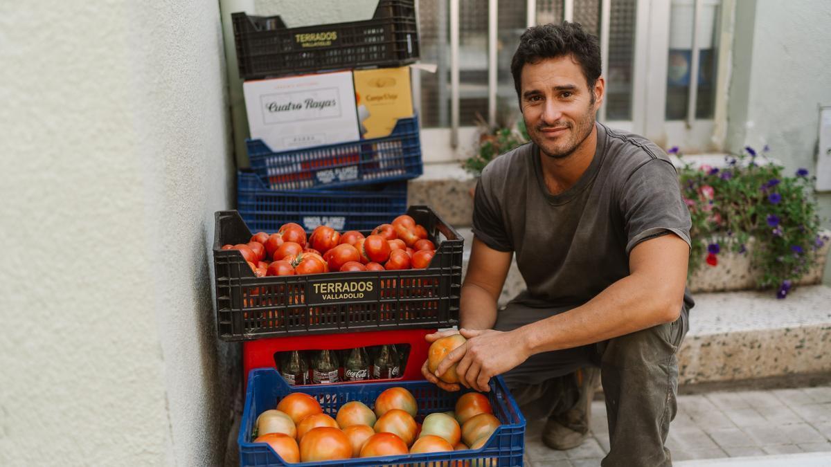 Maxi Esquivel, argentino, posa con los tomates de su invernadero en una de las calles de Paredes de Nava.