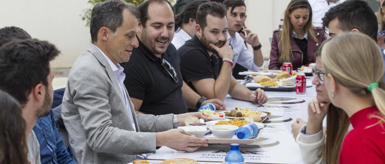 Pedro Duque recoge la bandeja que le entrega un alumno de la Politécnica con su menú.