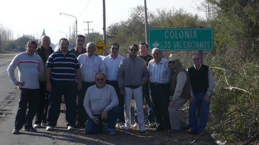 Emigrantes valencianos en Argentina, junto a la señal del lugar llamado «Colonia Los Valencianos».