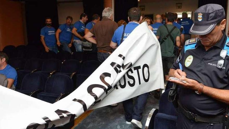 Un agente de la Policía Local identifica a alguno de sus compañeros, que abandonan la protesta ante el pleno de Pontevedra. // G. Santos