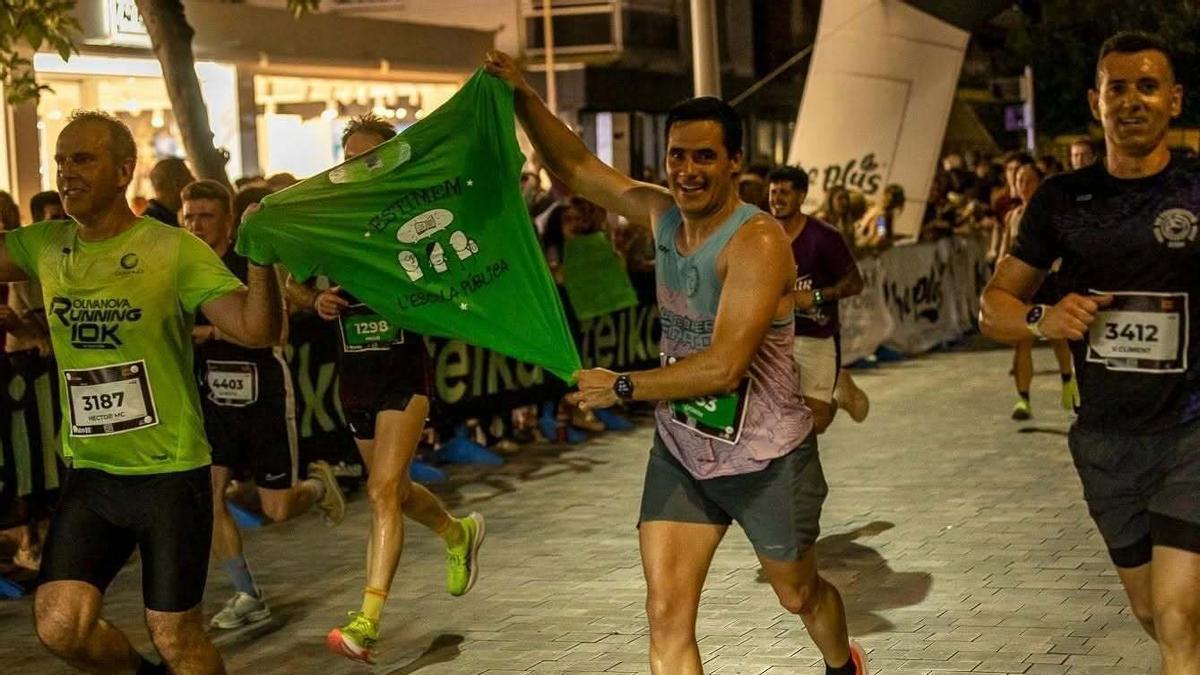 Dos participantes exhiben una camiseta de la "marea verde" en la 10K Gandia en apoyo a la huelga de los docentes
