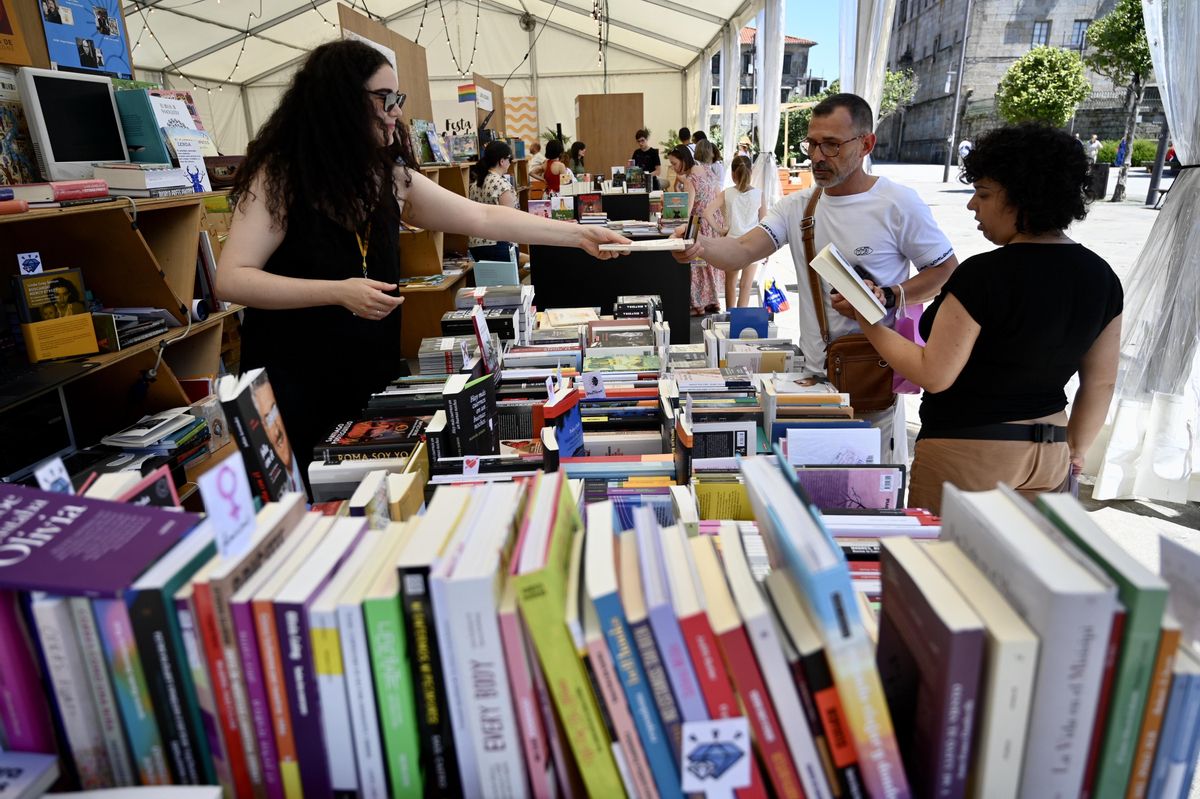 Lectores compran y ojean libros en uno de los puestos.