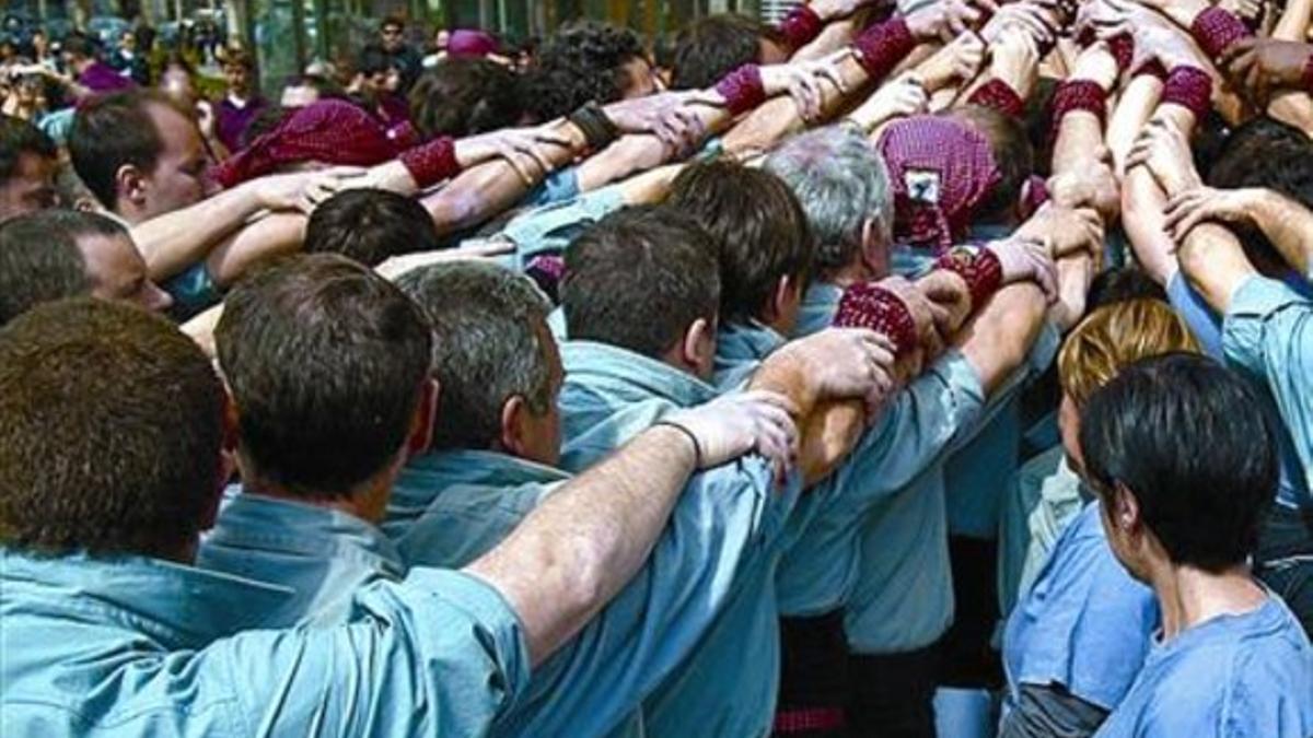 Miembros de los Castellers de Sants forman una piña.