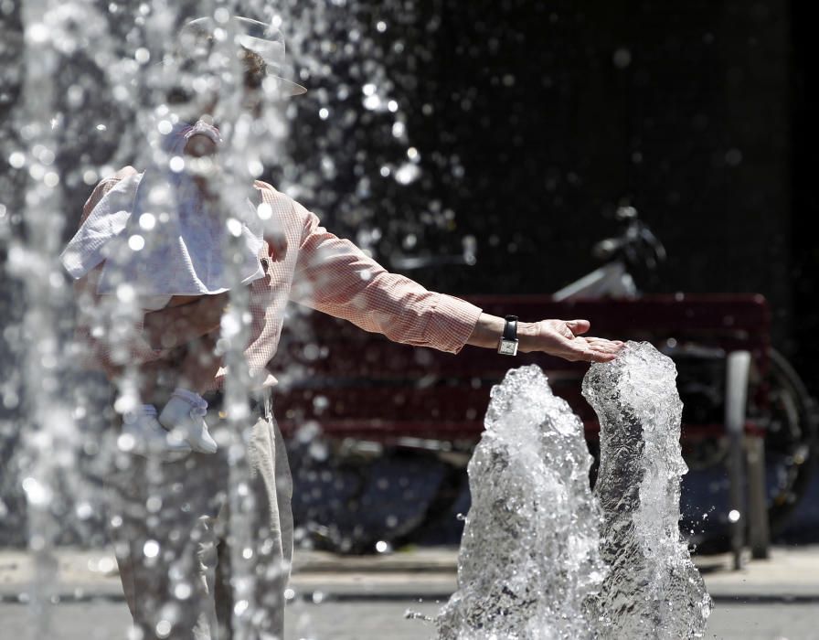 Una persona se refresca en una fuente.