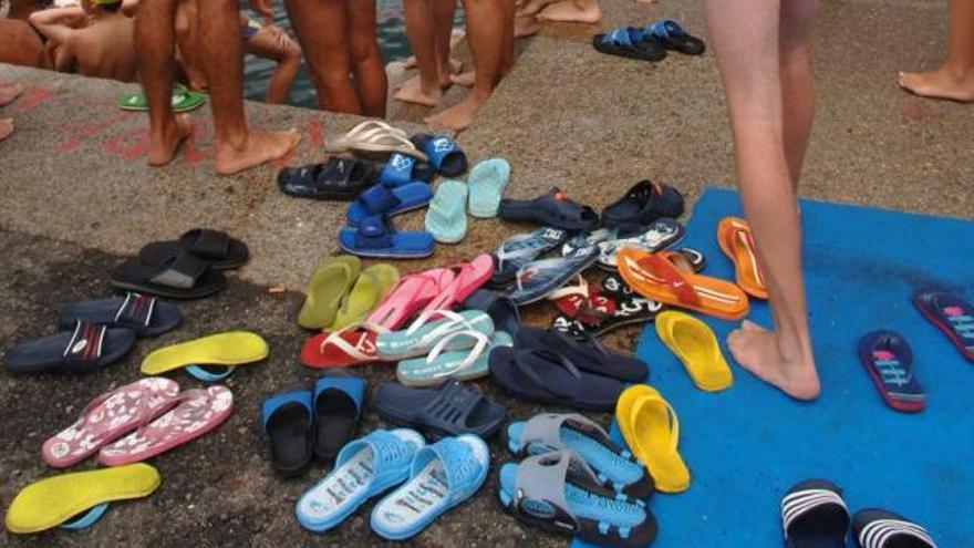 Varias chanclas amontonadas en una piscina. / carlos pardellas